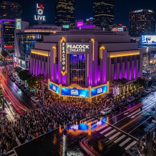 Aerial shot of the Peacock Theater in Los Angeles at night, illuminated with dramatic purple and gold lighting, crowds gathering outside the venue for the Game Awards ceremony